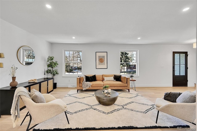 living area with recessed lighting, light wood-style flooring, and baseboards