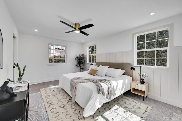 bedroom with carpet floors, a decorative wall, a ceiling fan, and recessed lighting