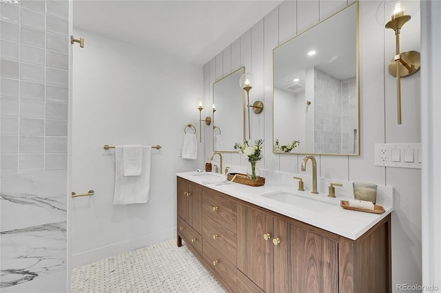 bathroom with double vanity, visible vents, baseboards, and a sink