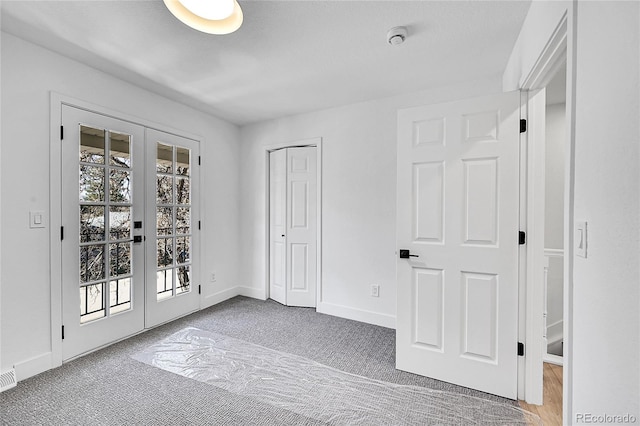 unfurnished room featuring french doors, visible vents, and baseboards