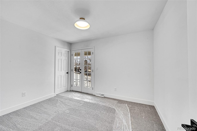 carpeted empty room with french doors, visible vents, and baseboards