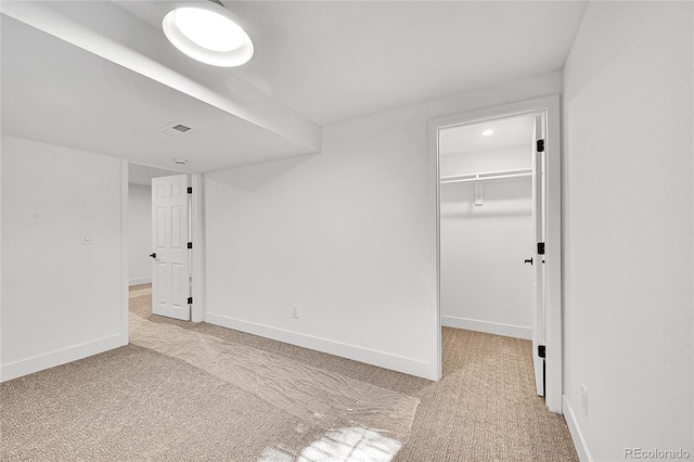 unfurnished room with visible vents, baseboards, and light colored carpet