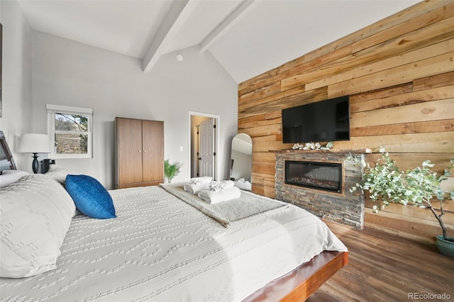 137 Hayden St, Cripple Creek, CO 80813 - bedroom featuring wood walls, a glass covered fireplace, wood finished floors, beam ceiling, and high vaulted ceiling