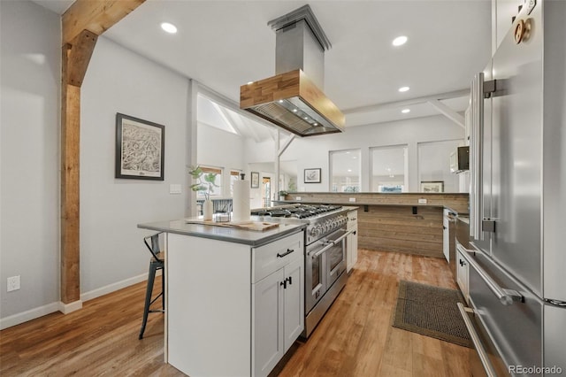 137 Hayden St, Cripple Creek, CO 80813 - kitchen with a kitchen breakfast bar, a kitchen island, island exhaust hood, premium appliances, and white cabinetry