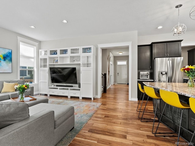 8012 E 50th Dr, Denver, CO 80238 - living area with light wood finished floors, a chandelier, and recessed lighting