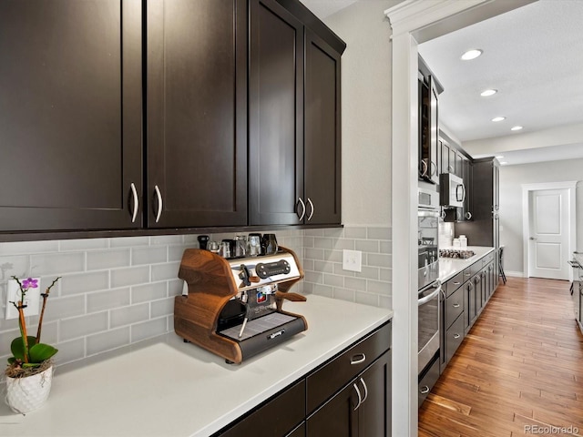 8012 E 50th Dr, Denver, CO 80238 - kitchen featuring light countertops, light wood-style flooring, dark brown cabinetry, recessed lighting, and backsplash