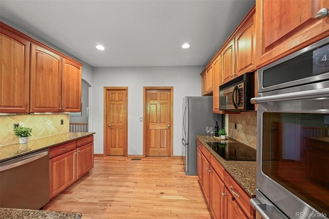 6475 Umber Cir, Arvada, CO 80007 - kitchen with black appliances, stone countertops, light wood-type flooring, recessed lighting, and backsplash