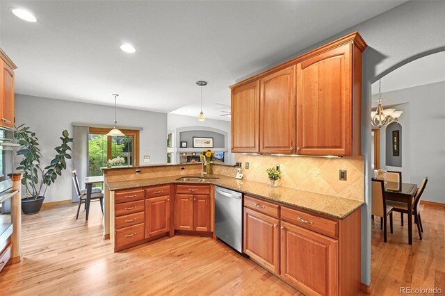 6475 Umber Cir, Arvada, CO 80007 - kitchen with stainless steel appliances, arched walkways, a peninsula, light wood-style flooring, and tasteful backsplash