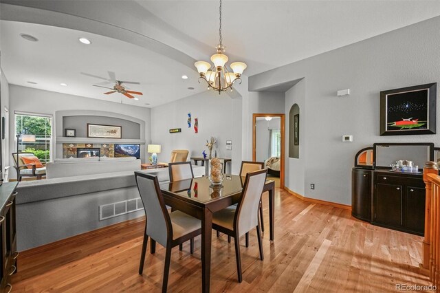 6475 Umber Cir, Arvada, CO 80007 - dining area featuring light wood finished floors, a chandelier, recessed lighting, a ceiling fan, and arched walkways