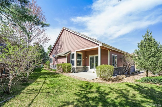 6475 Umber Cir, Arvada, CO 80007 - back of property featuring a yard, stone siding, and a patio area