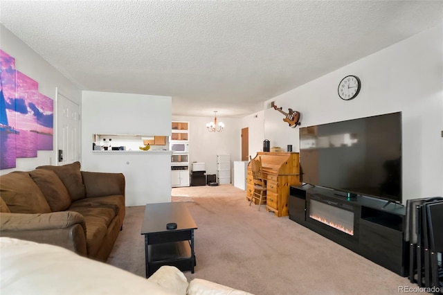 living area with a chandelier, carpet floors, and a textured ceiling