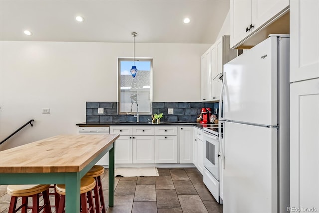 kitchen with backsplash, white appliances, sink, white cabinets, and hanging light fixtures