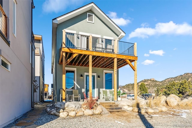 back of house featuring a mountain view and a balcony