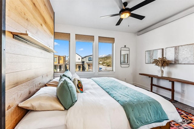 bedroom featuring ceiling fan and wooden walls