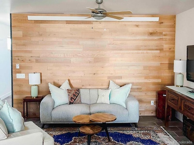 living room featuring ceiling fan and wood walls