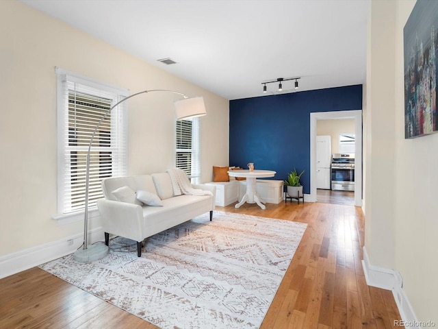 living room with hardwood / wood-style floors and rail lighting