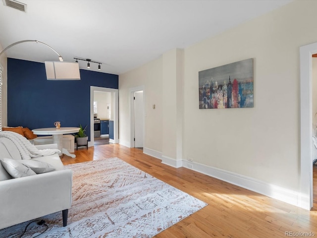 living room featuring rail lighting and hardwood / wood-style floors