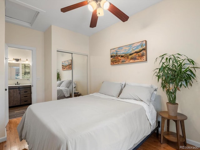 bedroom featuring connected bathroom, sink, a closet, ceiling fan, and hardwood / wood-style floors