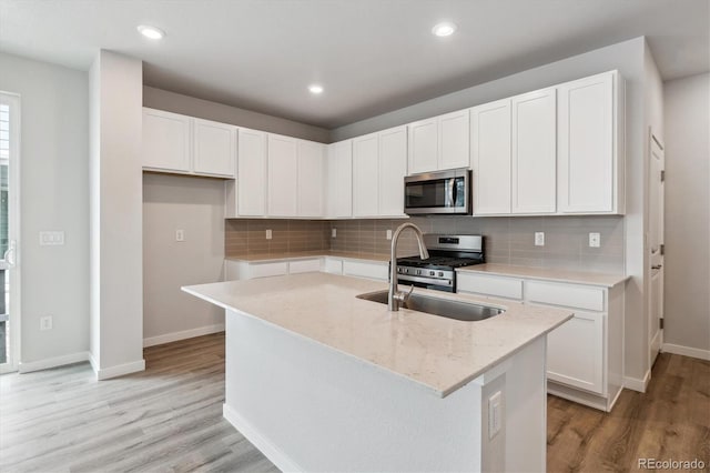14101 Deertrack Ln, Parker, CO 80134 - kitchen featuring stainless steel appliances, light wood-style flooring, baseboards, white cabinetry, and recessed lighting