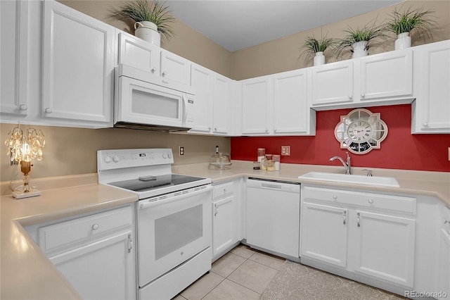 kitchen featuring white appliances, white cabinetry, and sink