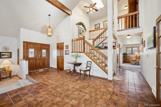 5245 Sapphire Dr, Colorado Springs, CO 80918 - entrance foyer with high vaulted ceiling, stairway, a ceiling fan, beamed ceiling, and baseboards