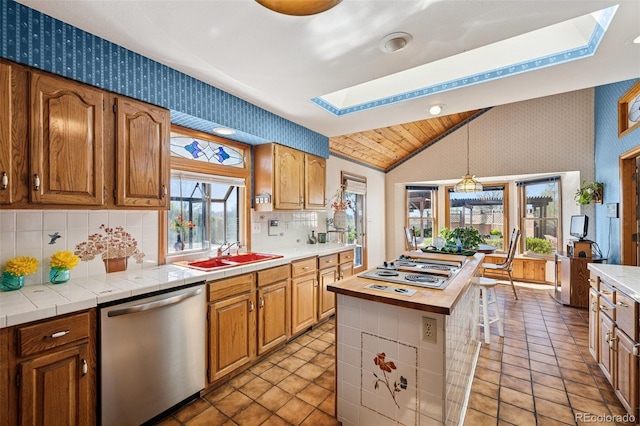 5245 Sapphire Dr, Colorado Springs, CO 80918 - kitchen featuring appliances with stainless steel finishes, wallpapered walls, a skylight, lofted ceiling, and a sink