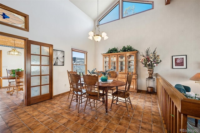 5245 Sapphire Dr, Colorado Springs, CO 80918 - dining room with high vaulted ceiling, a chandelier, dark tile patterned floors, and baseboards