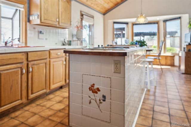 5245 Sapphire Dr, Colorado Springs, CO 80918 - kitchen featuring vaulted ceiling, light countertops, a kitchen island, wooden ceiling, and light tile patterned floors