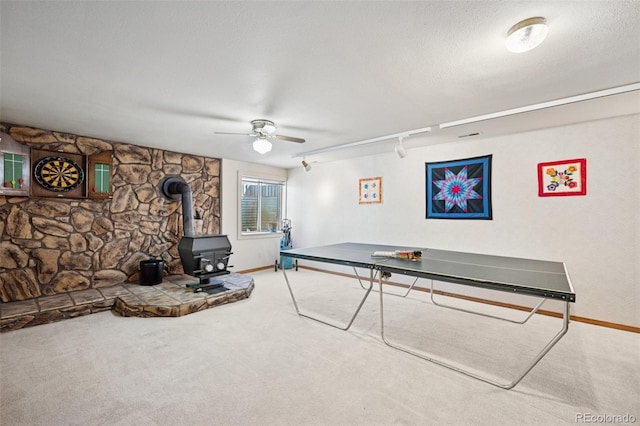 5245 Sapphire Dr, Colorado Springs, CO 80918 - rec room featuring a wood stove, carpet flooring, ceiling fan, baseboards, and rail lighting