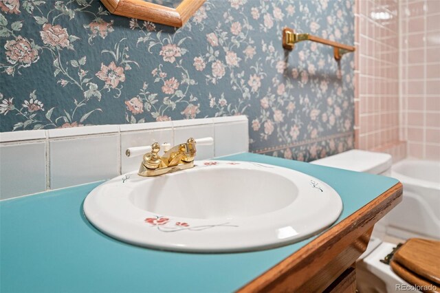 5245 Sapphire Dr, Colorado Springs, CO 80918 - bathroom featuring wallpapered walls, vanity, and a tub