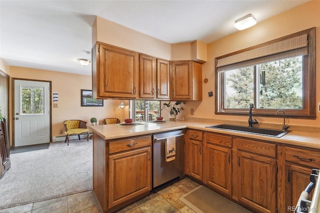 kitchen with a sink, brown cabinetry, dishwasher, and light countertops