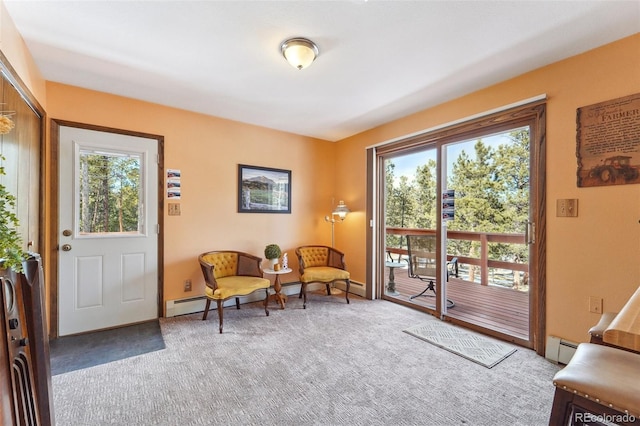 living area featuring baseboard heating and carpet flooring