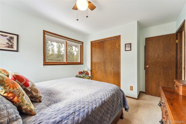 bedroom with ceiling fan, baseboards, a closet, and light colored carpet