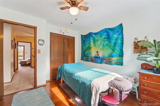 bedroom with a closet, ceiling fan, baseboards, and wood finished floors