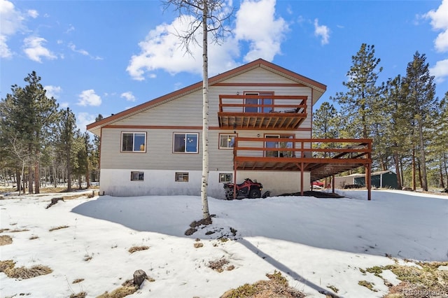 snow covered house featuring a deck