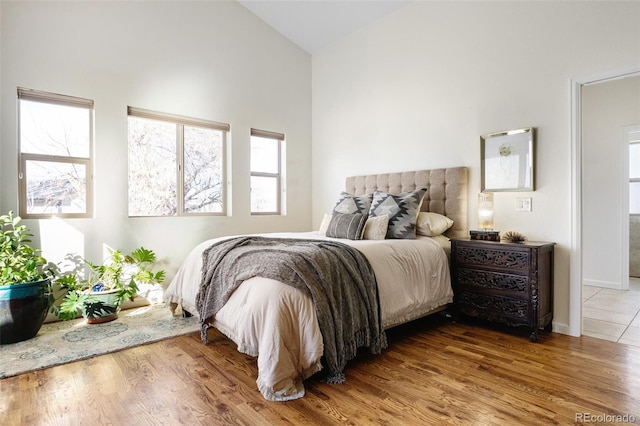 7551 S Garland St, Littleton, CO 80128 - bedroom featuring high vaulted ceiling, wood finished floors, and multiple windows