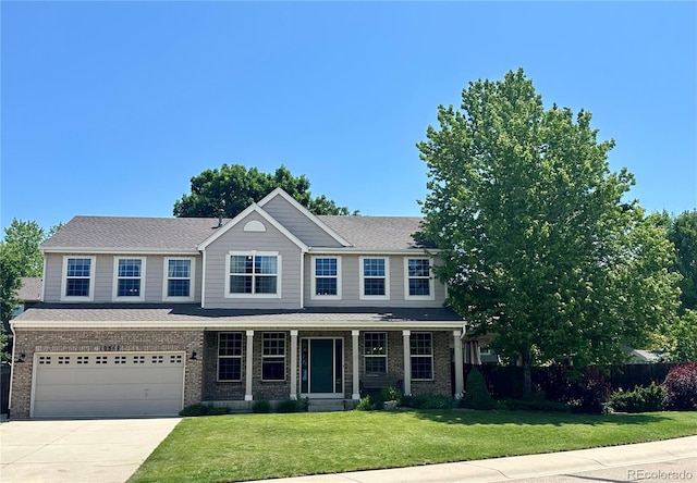 10512 Cimarron St, Longmont, CO 80504 - view of front of house with driveway, an attached garage, and brick siding