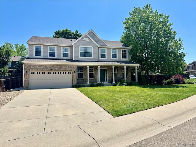 10512 Cimarron St, Longmont, CO 80504 - view of front facade featuring driveway, brick siding, covered porch, and an attached garage