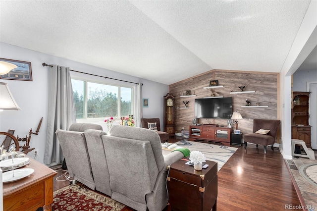 living room with wood finished floors, lofted ceiling, wood walls, a textured ceiling, and an accent wall