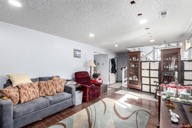 living area with wood finished floors, recessed lighting, visible vents, and a textured ceiling