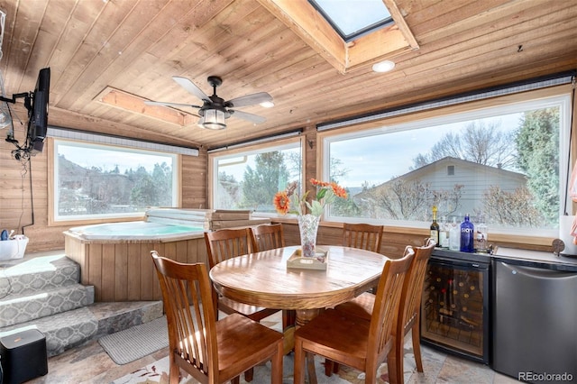 sunroom / solarium featuring a skylight, wood ceiling, beverage cooler, and ceiling fan