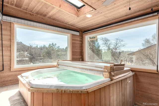 misc room featuring a jacuzzi, wooden walls, wood ceiling, and a skylight