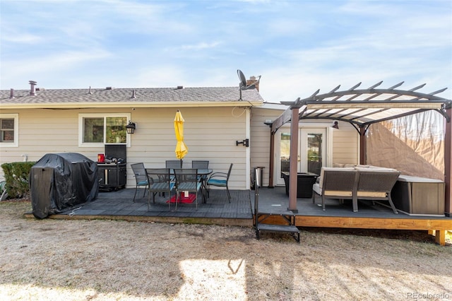 back of property featuring a wooden deck and a pergola