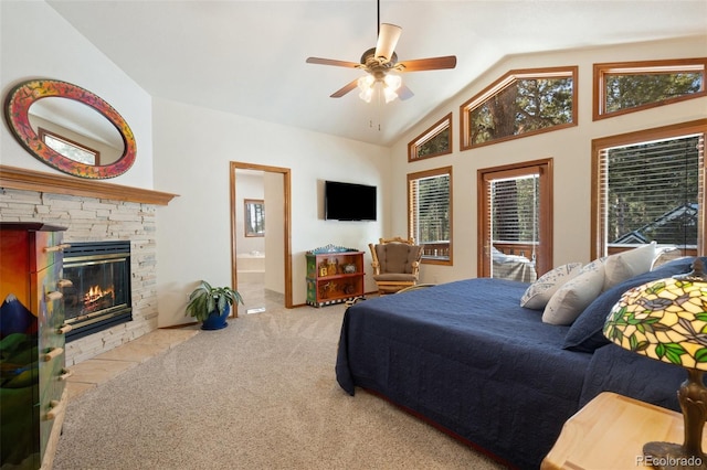 bedroom with lofted ceiling, ceiling fan, connected bathroom, a fireplace, and light colored carpet