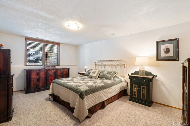 bedroom with light colored carpet and a textured ceiling