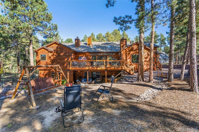 back of house with a deck and a patio