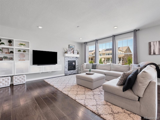 14565 Vancouver Pl, Parker, CO 80134 - living room with dark wood-type flooring, a textured ceiling, a stone fireplace, and recessed lighting
