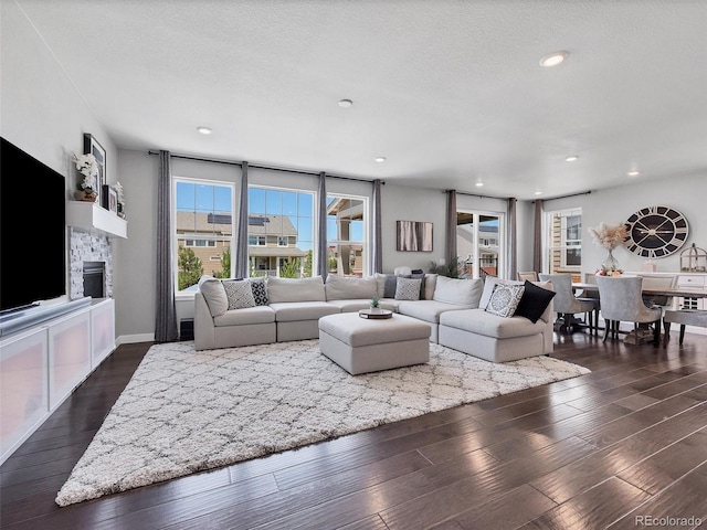 14565 Vancouver Pl, Parker, CO 80134 - living room featuring dark wood finished floors, a stone fireplace, and recessed lighting