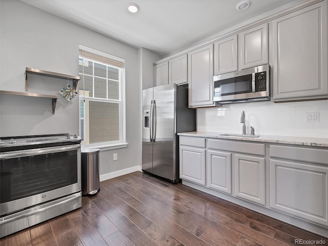 14565 Vancouver Pl, Parker, CO 80134 - kitchen with stainless steel appliances, decorative backsplash, dark wood finished floors, light stone countertops, and gray cabinets