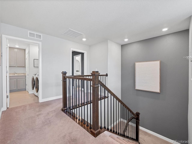 14565 Vancouver Pl, Parker, CO 80134 - corridor with washing machine and clothes dryer, an upstairs landing, light colored carpet, and recessed lighting